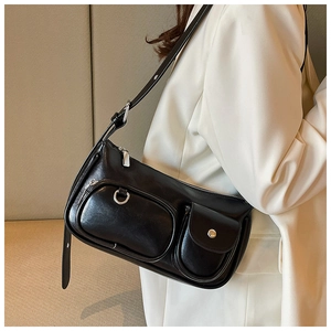Detail of black faux leather crossbody bag with silver hardware and utility pockets