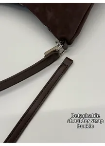Close-up of detachable silver metal buckle and strap on dark brown leather tote bag