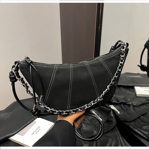 Detail of black crescent bag with white contrast stitching and silver chunky chain strap