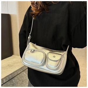 Close-up of a silver metallic rectangle bag with decorative pocket details and texture
