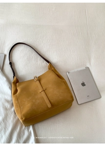 Détail du sac hobo en daim ambre avec bandoulière et comparaison de taille iPad