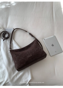 Detailed view of the dark brown matte shoulder bag with woven knot strap and silver buckle