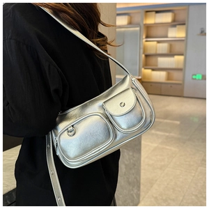 Detail view of silver PU leather bag with functional front pockets and metallic eyelet strap