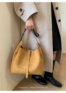 Détail du cabas en daim moutarde avec boucle rétro et fine bandoulière en cuir