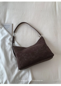 Close-up of retro brown hobo bag showing matte texture and silver metallic zipper details