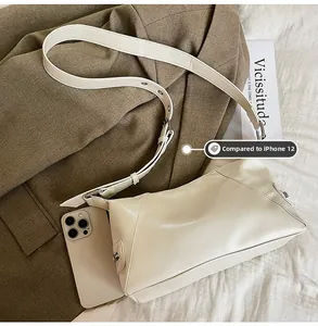 Detailed view of cream PU leather shoulder bag size compared to an iPhone 12