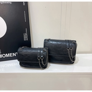 Comparison of two sizes of black chevron quilted chain bags with a modern minimalist style