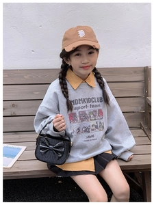 Girl wearing black crocodile pattern handbag with cute bow and sporty collegiate outfit