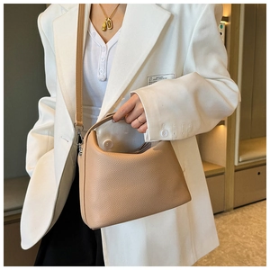 Nahaufnahme der beigen Lederstruktur mit Lychee-Maserung und Griffdetail der Tasche