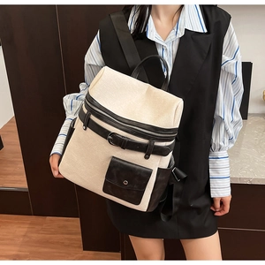 Detailed view of the textured canvas fabric and black leather straps on the stylish backpack