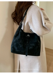 Détail d'un sac cabas noir mat minimaliste avec boucle argentée et texture vintage