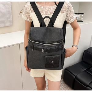 Detail view of large capacity dark grey backpack with stylish black leather accents