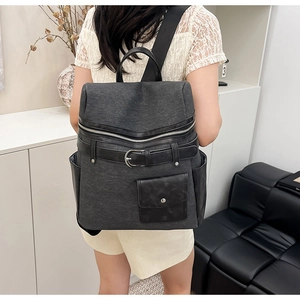 Detail of a chic canvas and leather backpack featuring contrasting strap buckle on the back