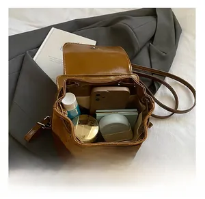 Interior view of brown leather backpack showing spacious compartment for cosmetics and phone
