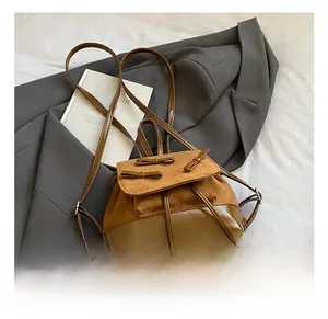 Close-up of bow details on stylish brown backpack with leather and suede texture