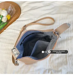 Innenstruktur der beigen Handtasche mit gestreiftem Futter und Reißverschlussfächern