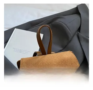 Detail of soft brown suede backpack handle with stylish decorative bow accent