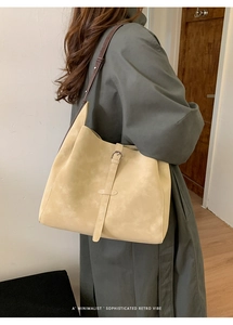Gros plan d'un sac cabas minimaliste crème avec une élégante bandoulière en cuir brun