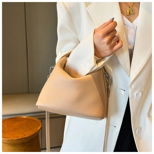 Detail der Lederhandtasche mit Litschi-Muster und verstellbarem Schultergurt am Model