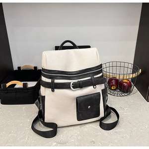 Detail view of the bicolor canvas and leather backpack with metal buckle and side pockets