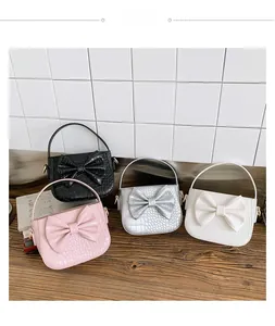Detail of four colorful crossbody bags featuring faux crocodile texture and large bows