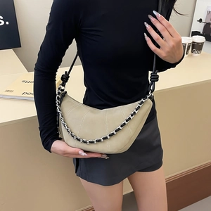 Sac croissant minimaliste en daim beige avec surpiqûres blanches et chaîne métallique