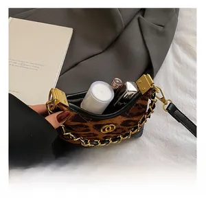 Detail view of leopard print plush handbag interior capacity with chunky gold chain