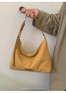 Detail of minimalist mustard yellow retro tote bag with unique leather knot shoulder strap