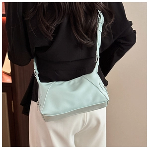 Adjustable mint green soft faux leather hobo bag worn by model in a daily casual style