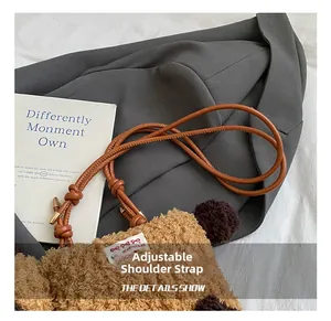 Détail du sac chiot en peluche avec bandoulière réglable et étiquette de Noël sur tissu