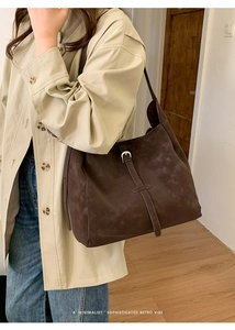 Gros plan d'un grand sac cabas minimaliste en daim marron avec boucle métallique décorative