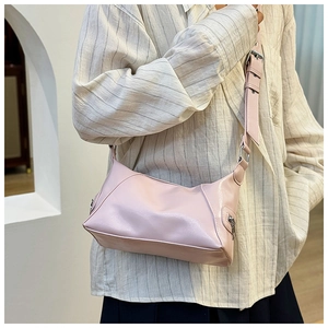 Detail of light pink moon-shaped tote bag in glossy PU leather with wide shoulder strap