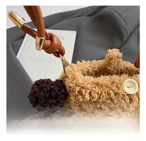 Détail du sac bandoulière en peluche avec crochet doré et bouton 'Handmade with love'