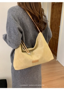 Detail of minimalist beige matte leather hobo bag shoulder strap and zipper closure