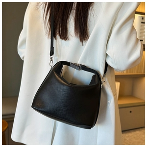 Nahaufnahme der schwarzen Handtasche mit Lychee-Maserung und silbernen Beschlägen