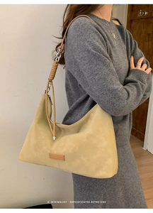Detail of minimalist beige tote bag with decorative wrapped shoulder strap and matte finish