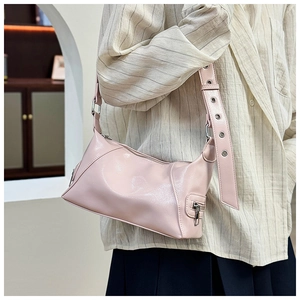 Pink glossy patent leather tote bag featuring large metallic eyelets on the wide strap