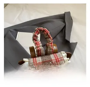 Detail of the ruffle handle and vintage red plaid fabric on the cartoon bear backpack