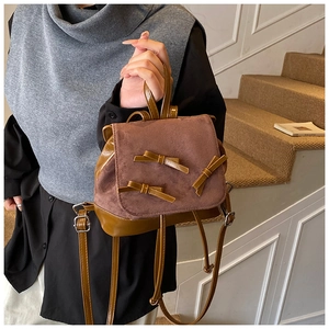 Close-up of a brown mini bow backpack featuring suede flap and dual-tone PU leather finish