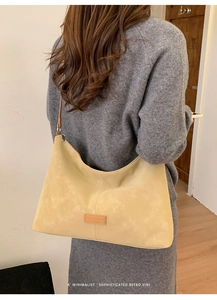Minimalist beige shoulder bag with subtle leather texture shown on person for daily style