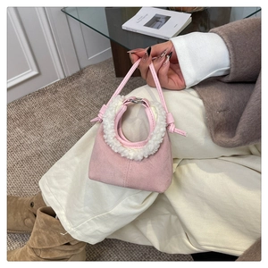 Dettaglio mini borsa in camoscio rosa con bordo in peluche bianco e tracolla in pelle fine