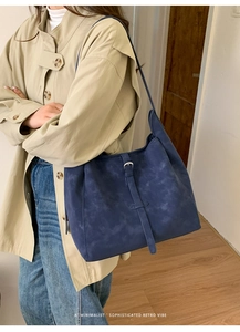 Détail du sac cabas rétro bleu avec boucle et texture vieillie sur le mannequin