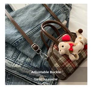 Détail montrant la boucle réglable sur la bandoulière du mini sac pour enfant à carreaux