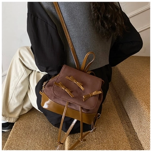 Close-up of a brown patchwork bow backpack on a model at stairs showing stylish textures