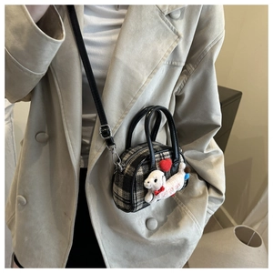 Détail du mini sac à carreaux avec charm chiot en peluche et décoration de coeur rouge