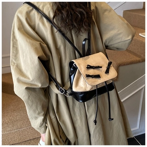 Mini bow-knot backpack in beige suede and black leather shown on a model