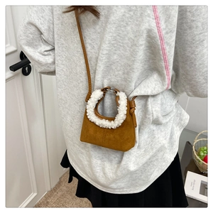 Detail of caramel suede bag with white faux shearling handle and slim shoulder strap