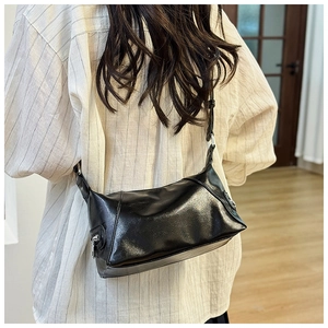 Rear view of a model wearing a chic black soft leather tote bag with silver hardware detail