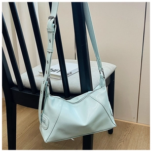 Close-up of light mint green soft leather tote bag with metal eyelet strap detail