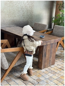 Kid's winter outfit detail with leopard print quilted chain bag in a cozy cafe setting